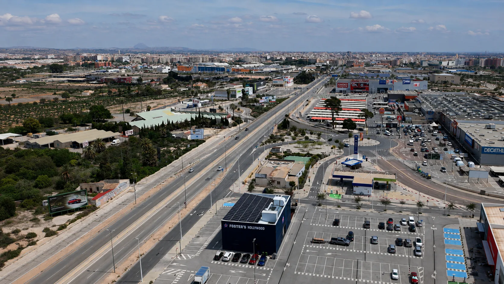 Vista aérea del corredor comercial de la avenida de Crevillente (N-340) en Elche, con Carrefour, Foster's Hollywood, Decathlon y el sector E-29